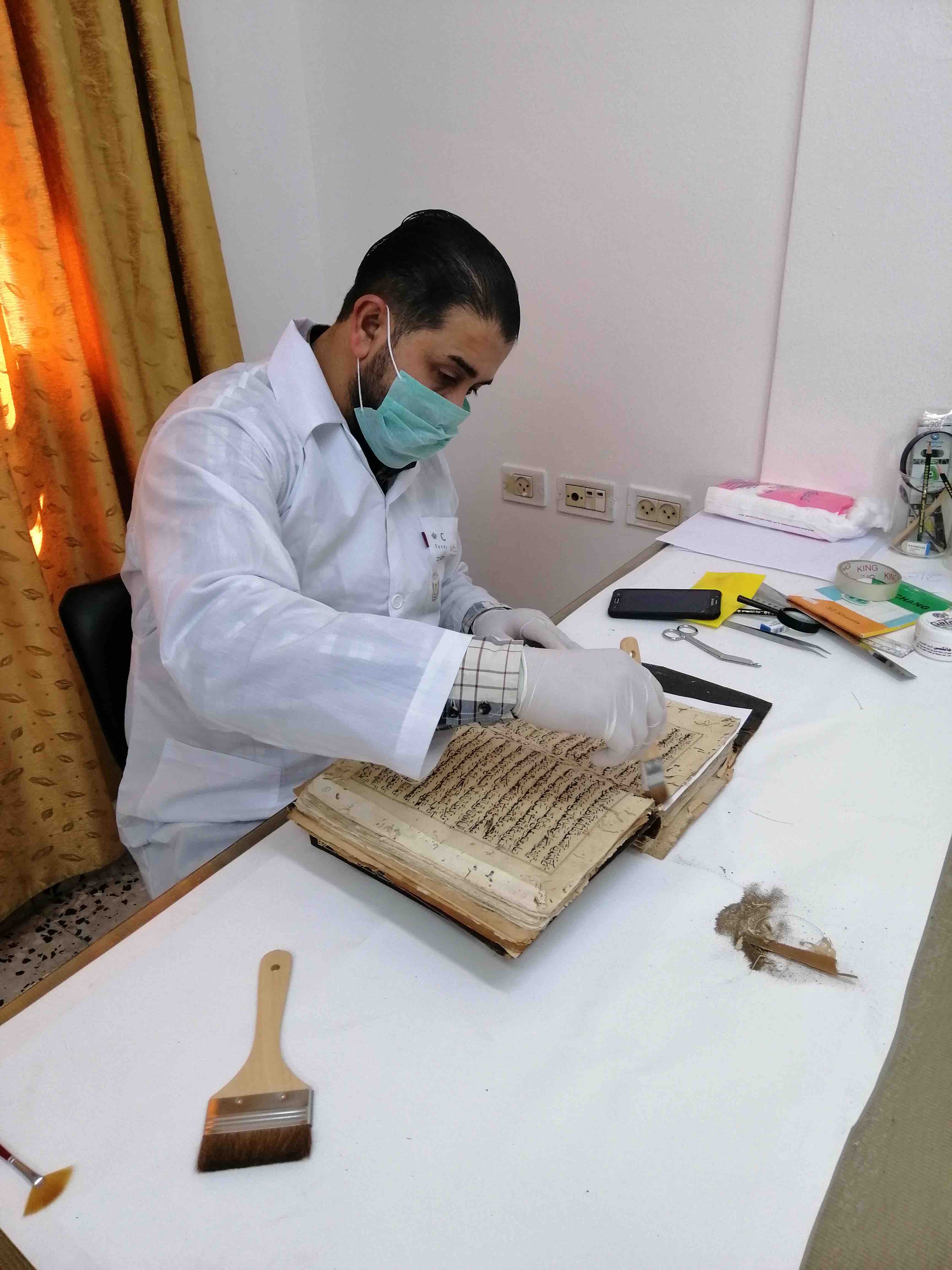 Technician Said Jalal cleaning a manuscript at the Great Omari Mosque